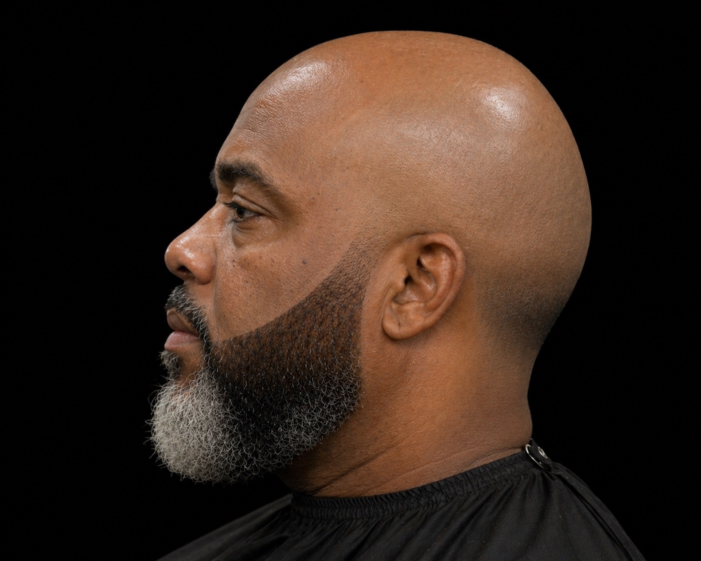 Bald Head with Faded Chinstrap and Grey Goatee — side profile barber reference photo showing the fade line and top shape