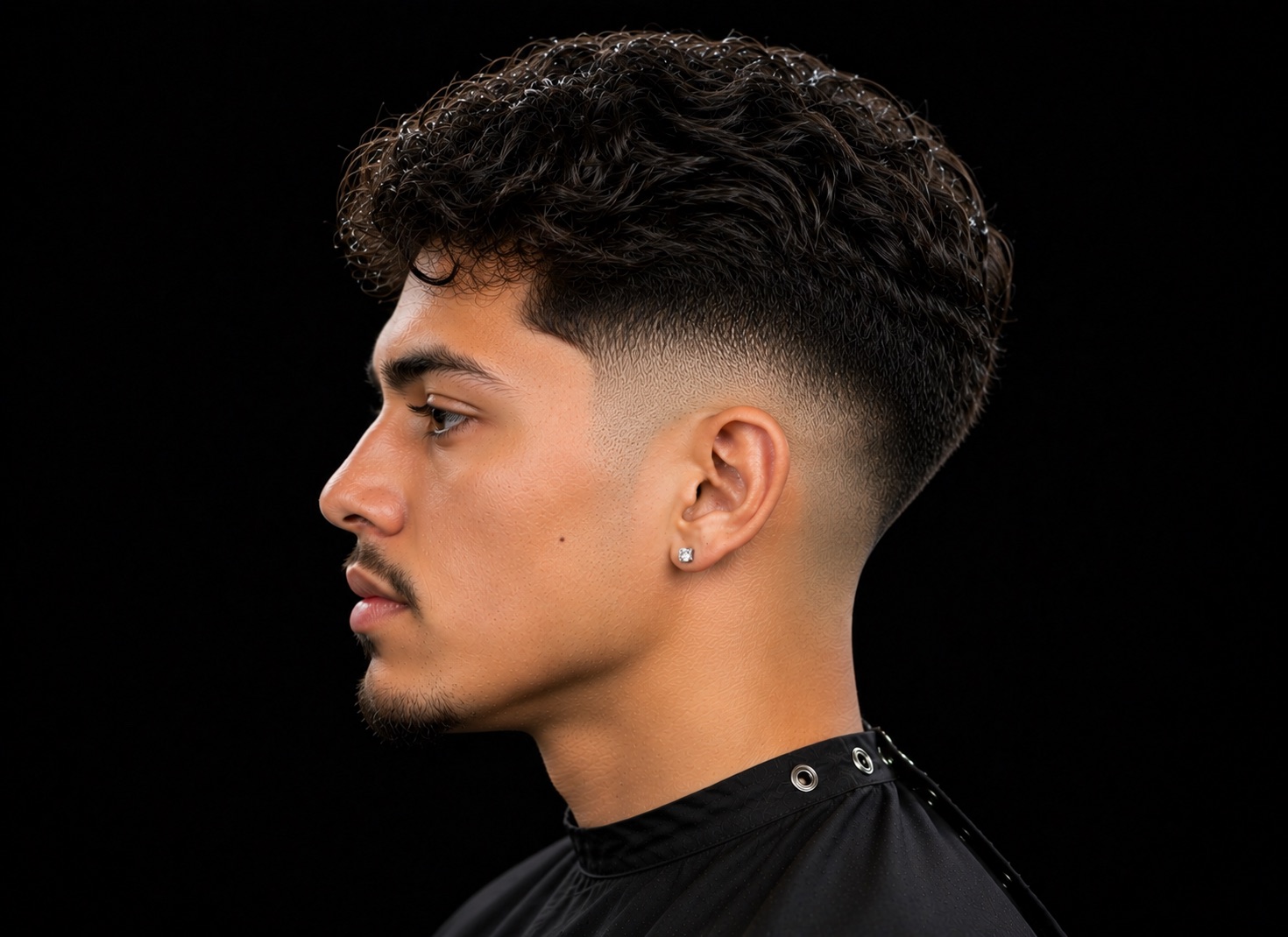 Low Taper Fade With Loose Curled Fringe — side profile barber reference photo showing the fade line and top shape